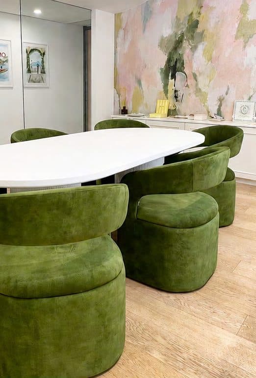 IuMi Studio a Milano, con sedie verde oliva e una parete illustrata su misura