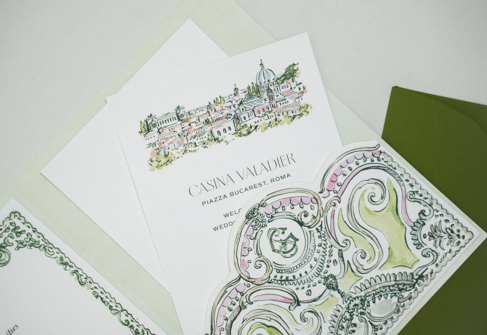 Welcome card with a watercolour view of Rome and a die-cut baroque pocket with monogram, on olive green and sage papers